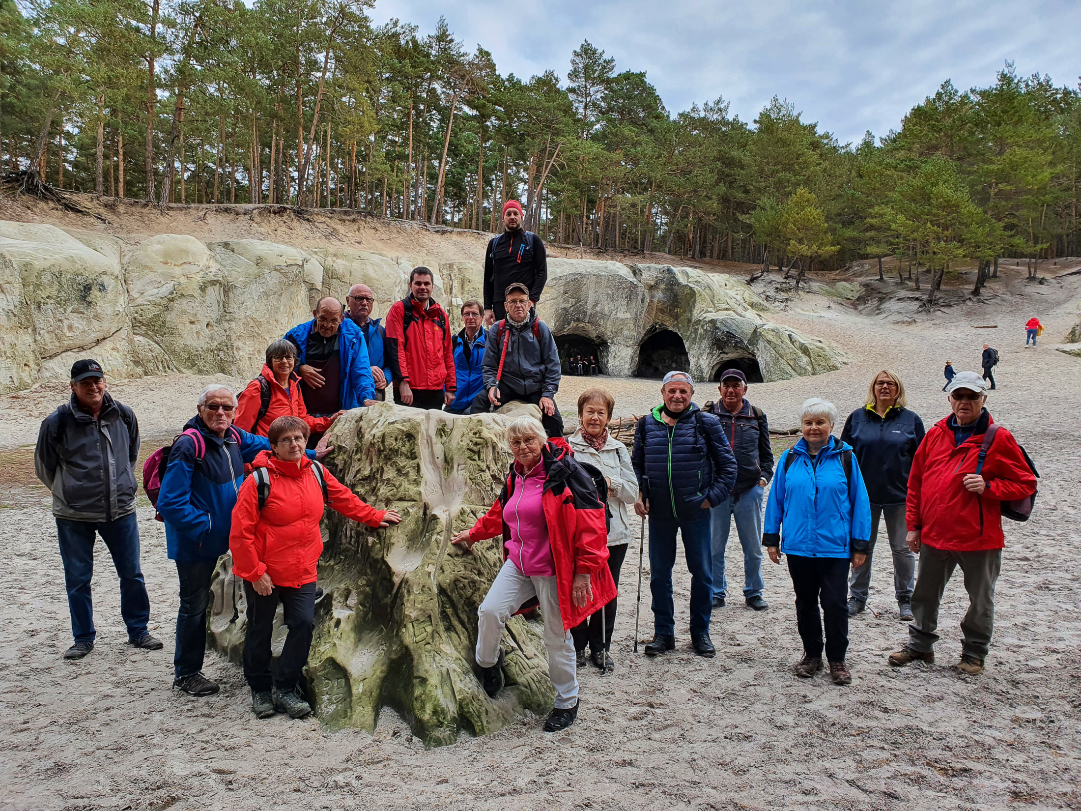 Sand unter den Füßen - Die Wandergruppe vor den großen Sandsteinhöhlen